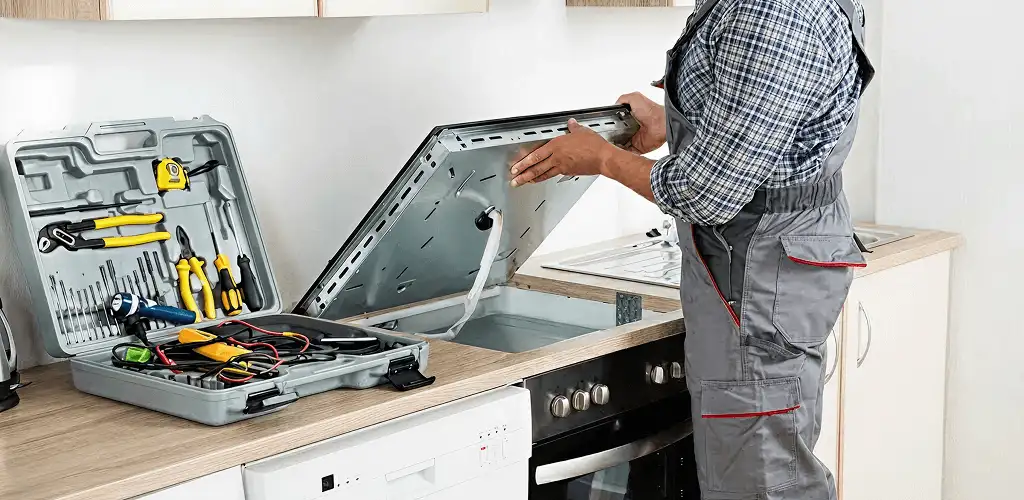 Handyman repairing a cooktop and checking wiring connections in Myrtle Beach, SC