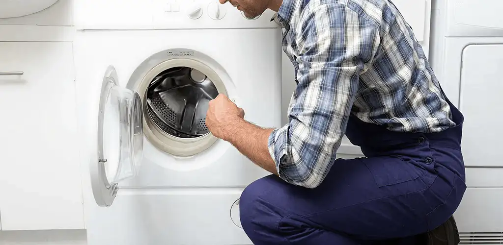 Handyman inspecting a dryer drum and internal parts for repair in Myrtle Beach, SC