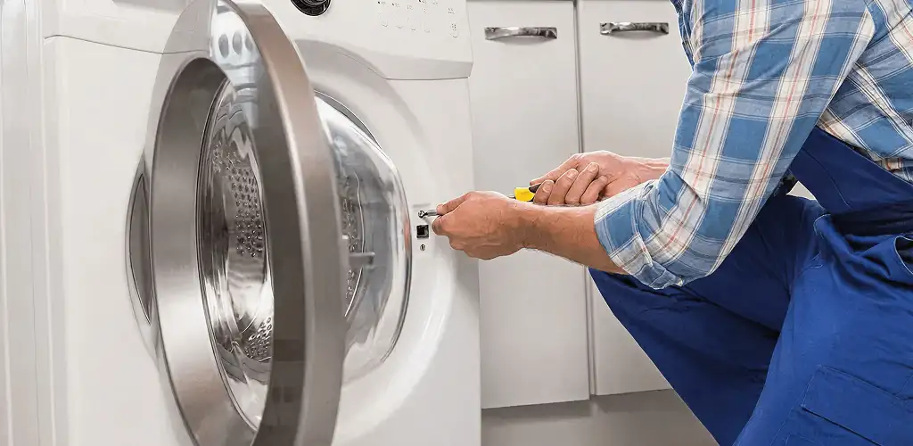 Handyman repairing a clothes dryer and checking electrical connections in Myrtle Beach, SC