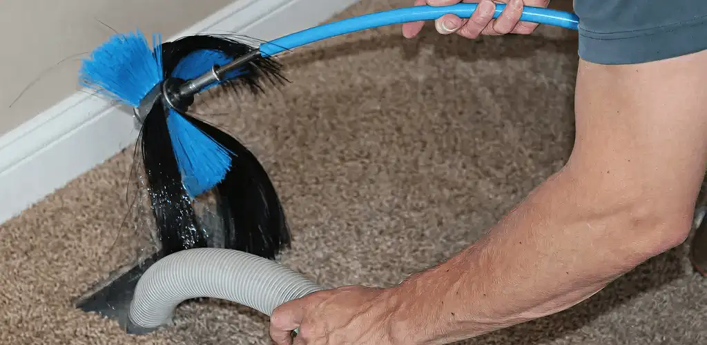 Dryer vent cleaning technician brushing lint from a vent line in Myrtle Beach, SC