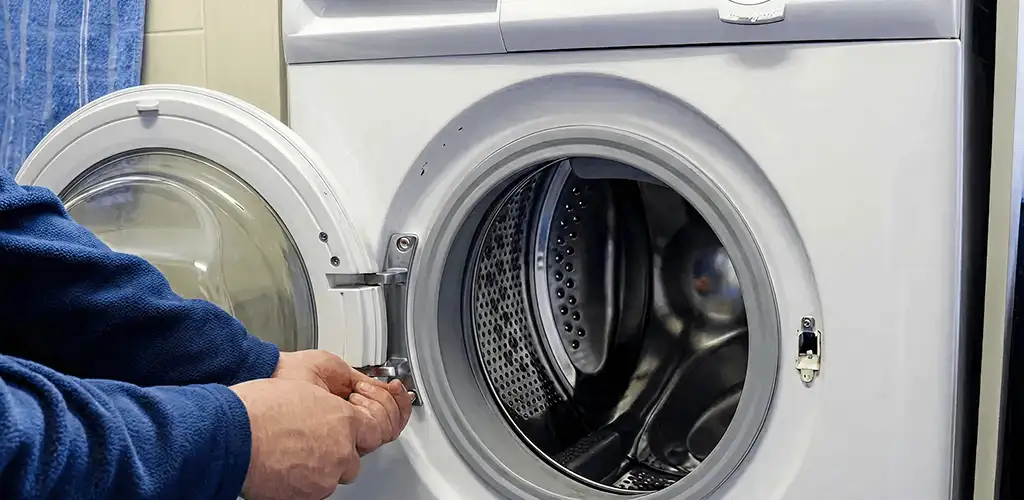 Washing machine repair handyman checking a front-load washer door and latch in Myrtle Beach, SC