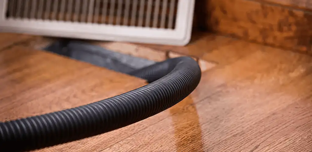 Air duct cleaning hose inserted into a floor vent for ductwork cleaning in Myrtle Beach, SC