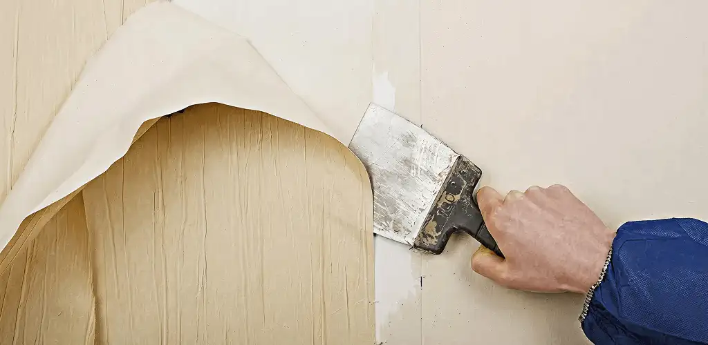 Handyman removing wallpaper with a scraper for wall preparation in Myrtle Beach, SC
