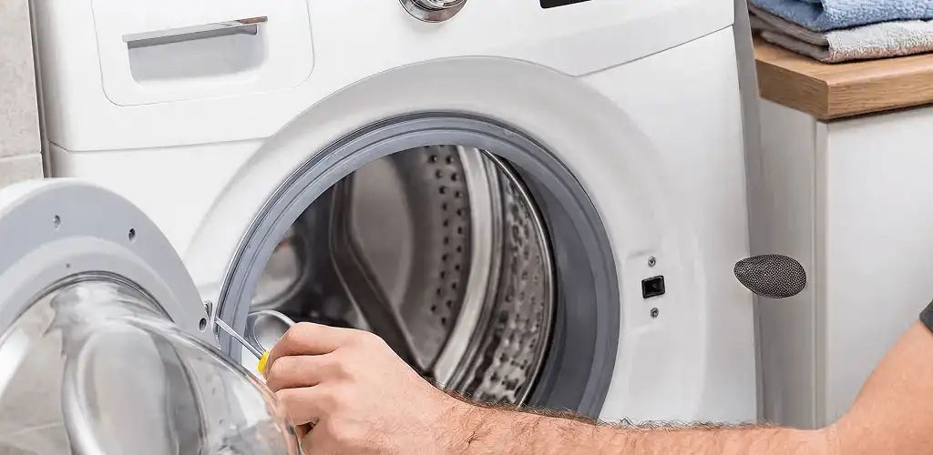 Handyman repairing a front-load washing machine and inspecting the drum in Myrtle Beach, SC