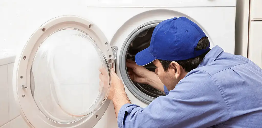 Washing machine repair handyman inspecting a front-load washer drum in Myrtle Beach, SC